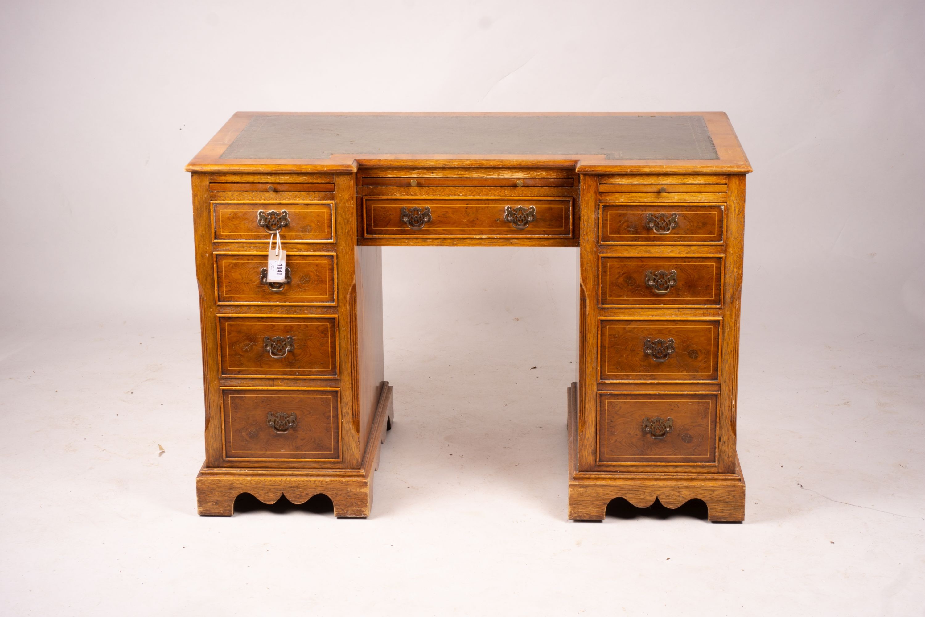 A reproduction yew inverse breakfront kneehole pedestal desk fitted green skiver, width 114cm, depth 58cm, height 77cm